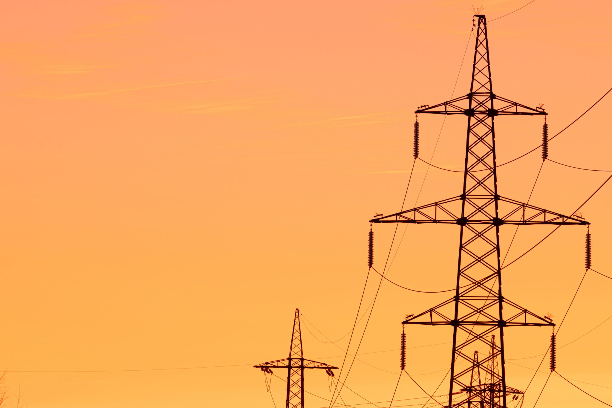 Transmission lines with an orange sky background