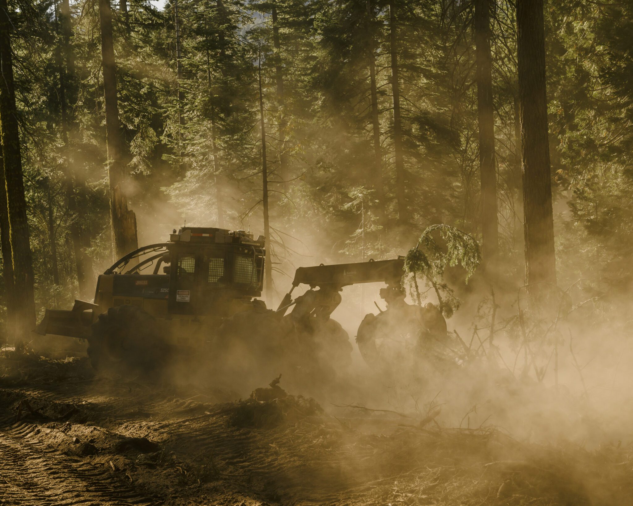 A logging skidder, controlled remotely by a Kodama Systems worker, clears out woods vulnerable to fast-moving fires in the Stanislaus National Forest, near Sonora, in Northern California, July 26, 2024. High-tech entrepreneurs are trying to use new forms of technology to solve the problem of mega-wildfires in the age of climate change. (Ian C. Bates/The New York Times)